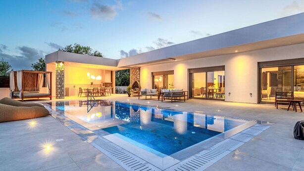 Una casa moderna amb piscina, zona de seients a l'exterior i menjador.