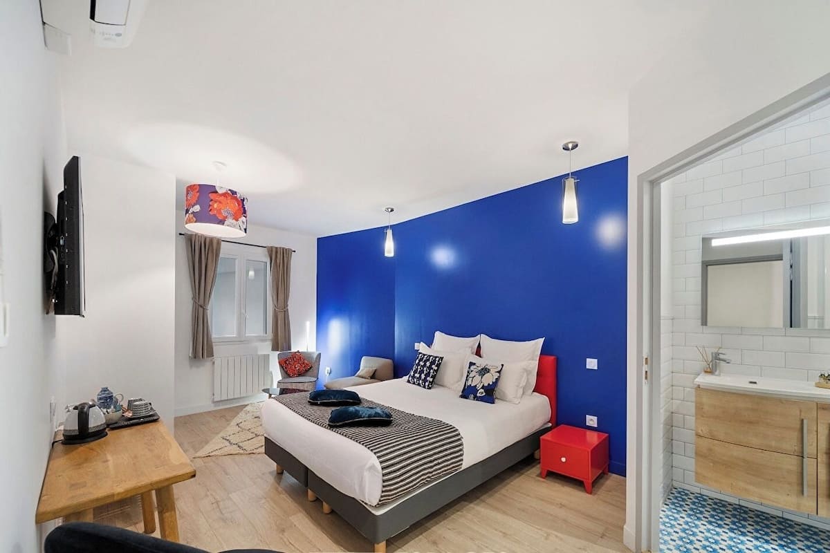 Una camera da letto moderna con un letto, un comodino e un tavolino da notte rosso.