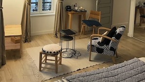A room with a bed, a desk, a chair, a television, and a patterned ceiling light.