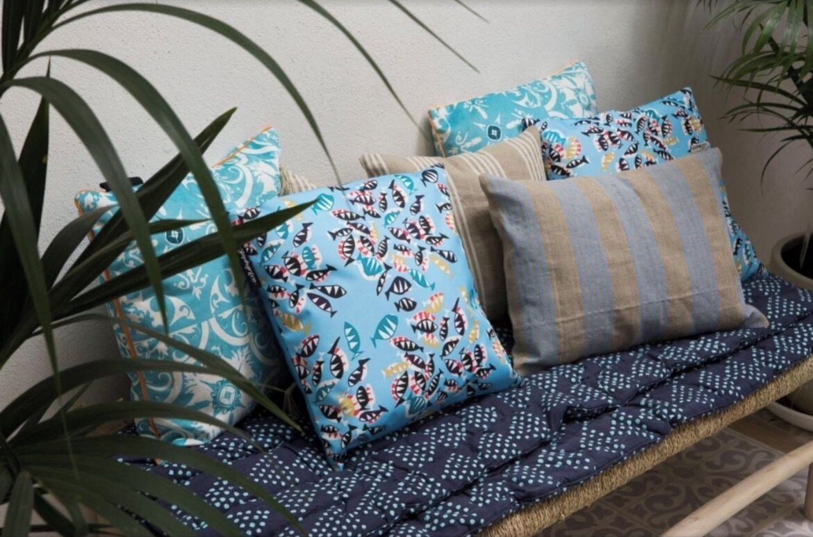 A bench with patterned cushions and a woven seat.