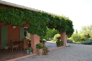 A building with a covered patio, outdoor seating, and a gravel driveway. - Magnificent Provençal villa in a quiet private domain (Tourtour)