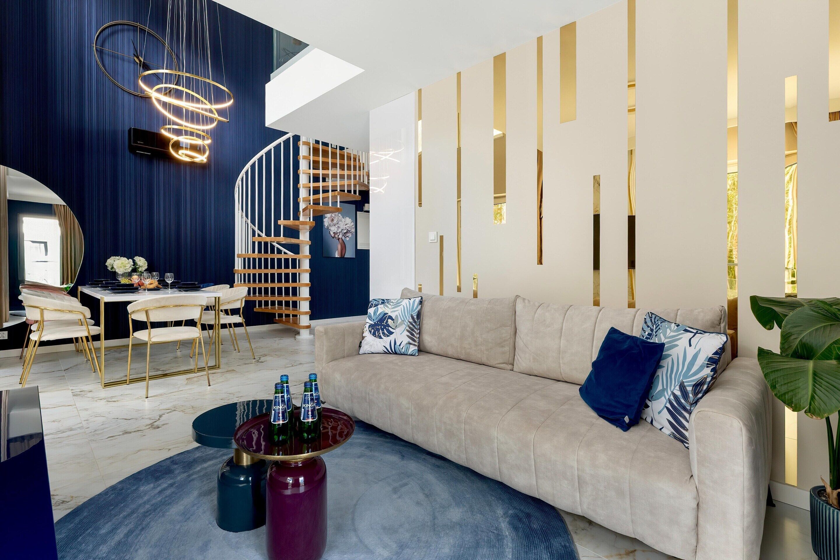 Un salon moderne comprenant un canapé, une table basse et un coin repas avec des chaises et une table.