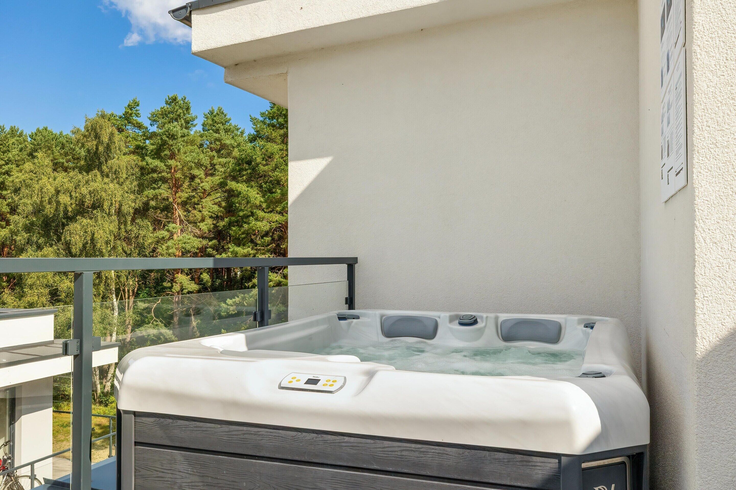 A hot tub on a balcony with a clear view of the surrounding trees.