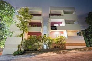 A multi-story building with balconies, a sign reading 'Townhouse,' and surrounding greenery. - Deluxe Hebbal Mysore Green Orchid Resort (Mysore)