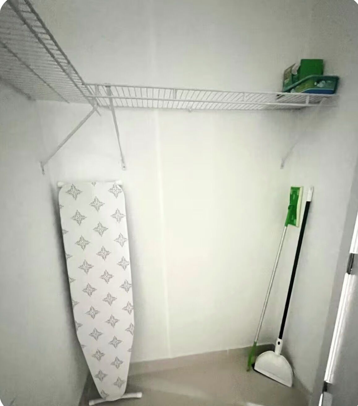 Un bagno con tenda doccia, uno straccio e uno scaffale con diversi oggetti.