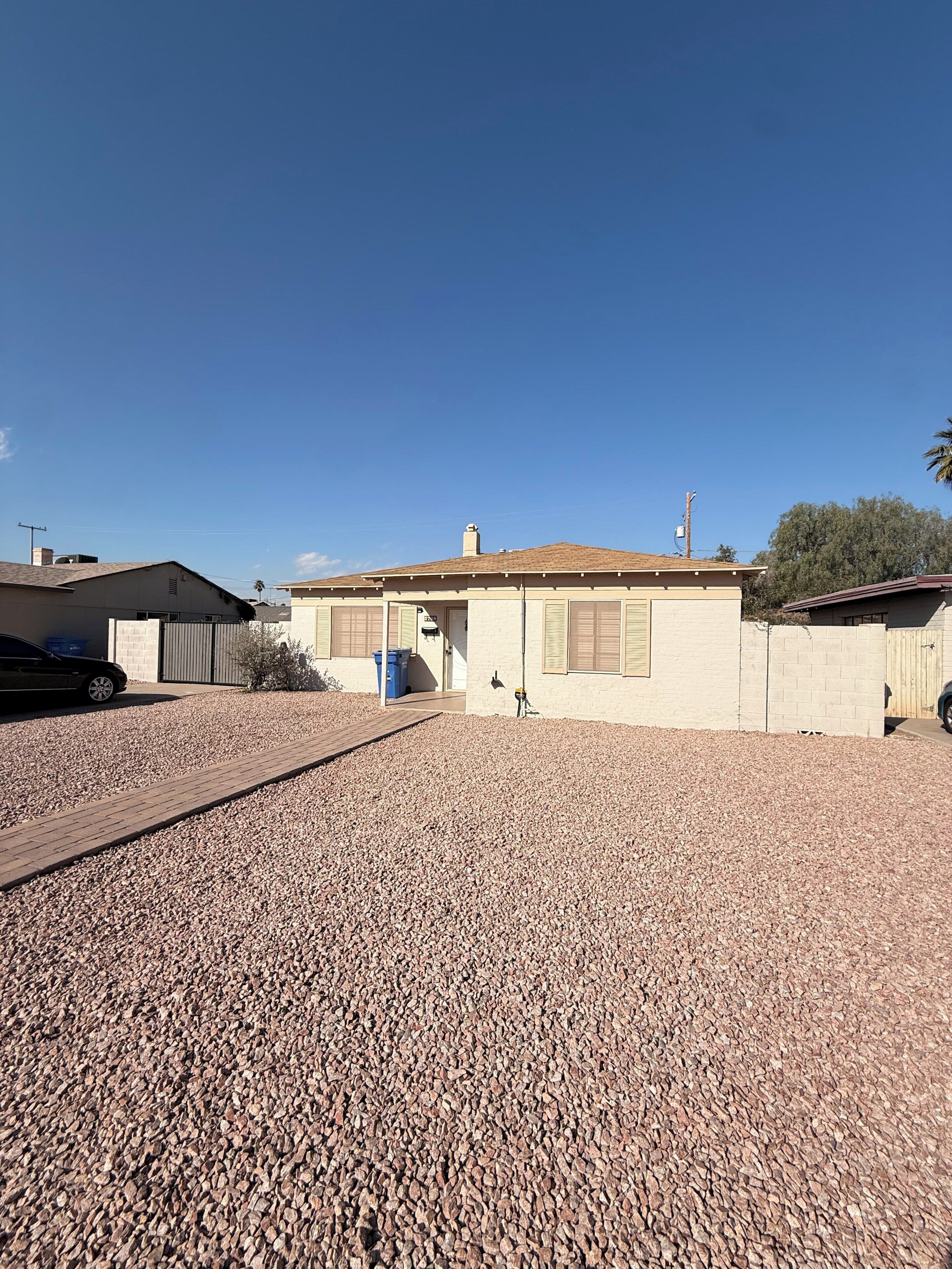 A residential property with a paved driveway, a garage, and a house with a tiled roof.