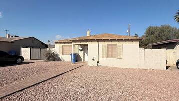 A residential property with a paved driveway, a garage, and a house with a tiled roof.