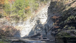 A natural landscape with a river, rocky cliffs, and trees.