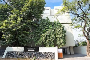 Un edificio con un cartel que dice 'TOWNHOUSE' y un muro de piedra en primer plano.