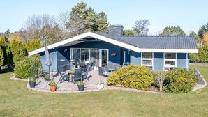 A modern house with a patio, outdoor seating, and a garage. - "Sofus" - 800m from the sea by Interhome (Væggerløse)