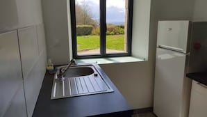 Una cocina con ventana, un fregadero y un refrigerador.