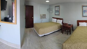 A hotel room with two beds, a desk, a chair, a TV, and a wardrobe. - Deluxe Inn Elkton (Elkton)