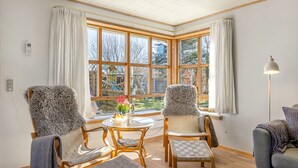 Ein Zimmer mit großem Fenster, Holzmöbeln und einer Lampe.