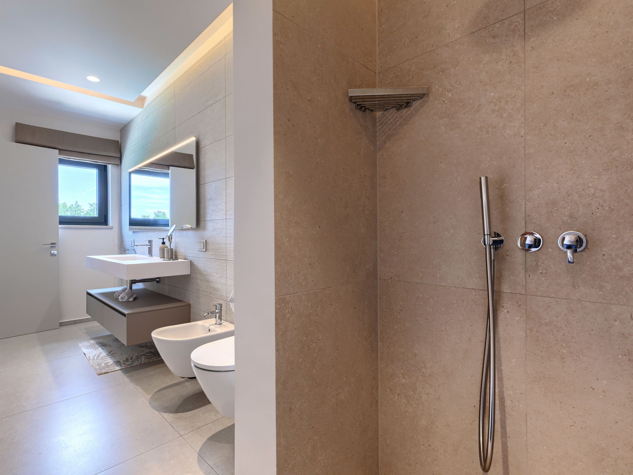 A modern bathroom with a shower, toilet, and sink.