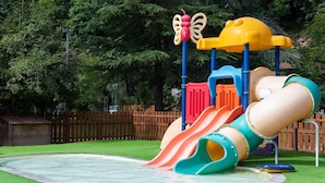 Ein Spielplatz mit Rutsche, Klettergerüst und einer schmetterlingsförmigen Dekoration.