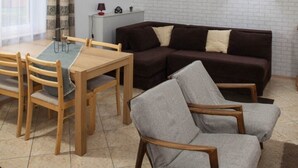 Een loft-achtig vertrek met een eethoek, een bank en een raam met uitzicht.