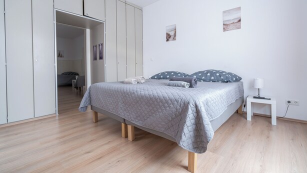 A bedroom with a bed, a wardrobe, a bedside table, and two wall-mounted pictures. - revLIVING OCTAVUS for up to 7 guests in the idyllic wine village of Hohenwarth-Mühlbach (Hohenwarth)
