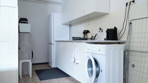 A compact laundry room with a washing machine, a small stool, and a metal rack. - revLIVING OCTAVUS for up to 7 guests in the idyllic wine village of Hohenwarth-Mühlbach (Hohenwarth)