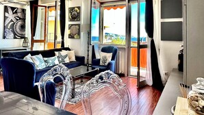 Ein modernes Wohnzimmer mit einer Couch, einem Couchtisch und Blick durch eine Glastür.