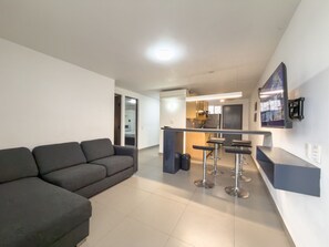 A modern apartment with a living area, kitchenette, and a bar area. - Suite ejecutiva a Pasos del TEC (Monterrey)