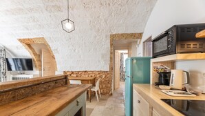 A compact kitchen with a wooden counter, a teal refrigerator, and a black microwave. - Le Terrazze Del Sud - Salve (Salve)