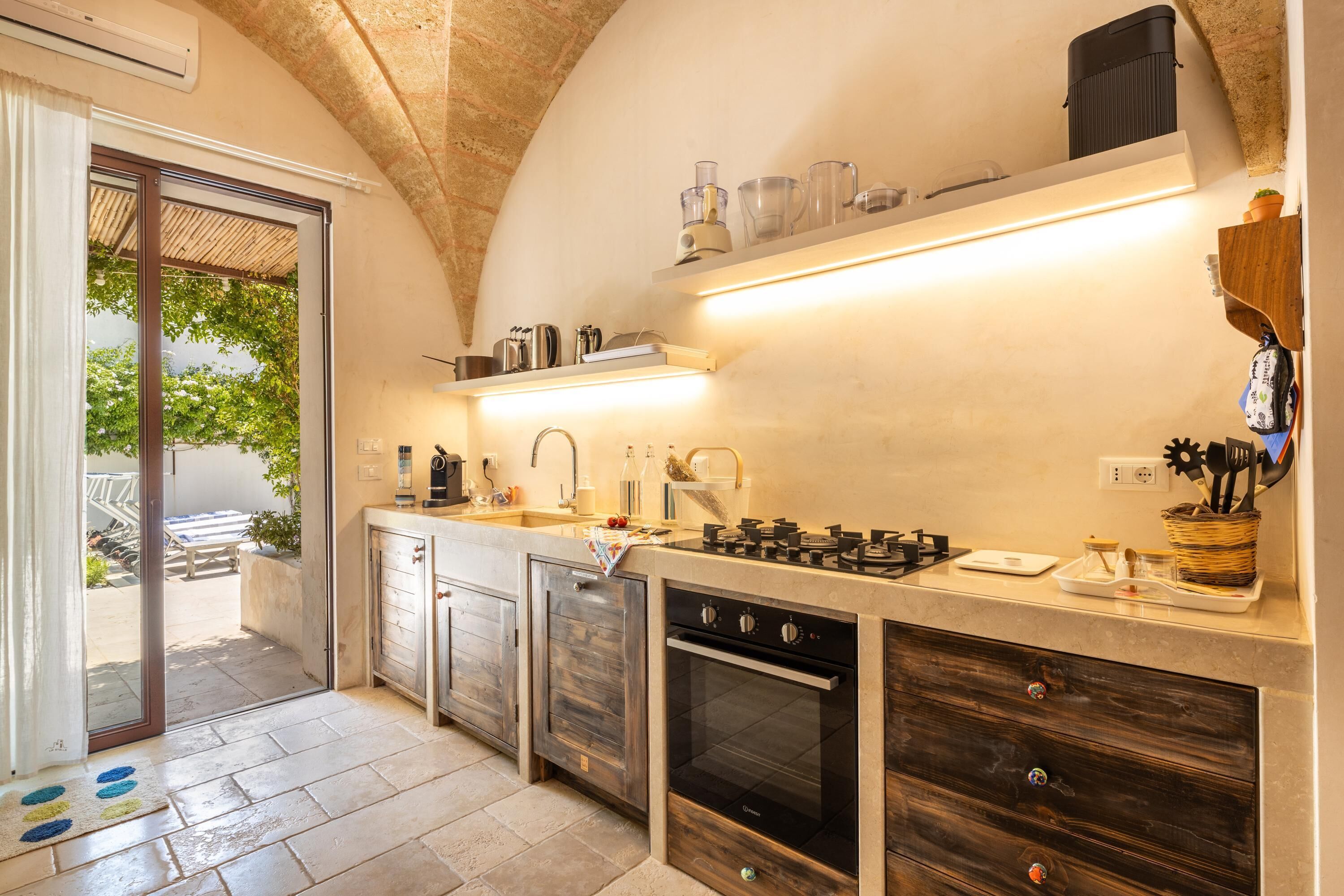 A compact kitchen with a gas stove, a sink, and a built-in oven.
