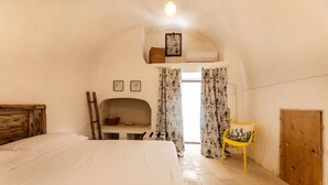 A bedroom with a bed, a wooden headboard, a desk with a chair, a wardrobe, and a window with curtains. - Villa Terra E Sale - Salve (Salve)