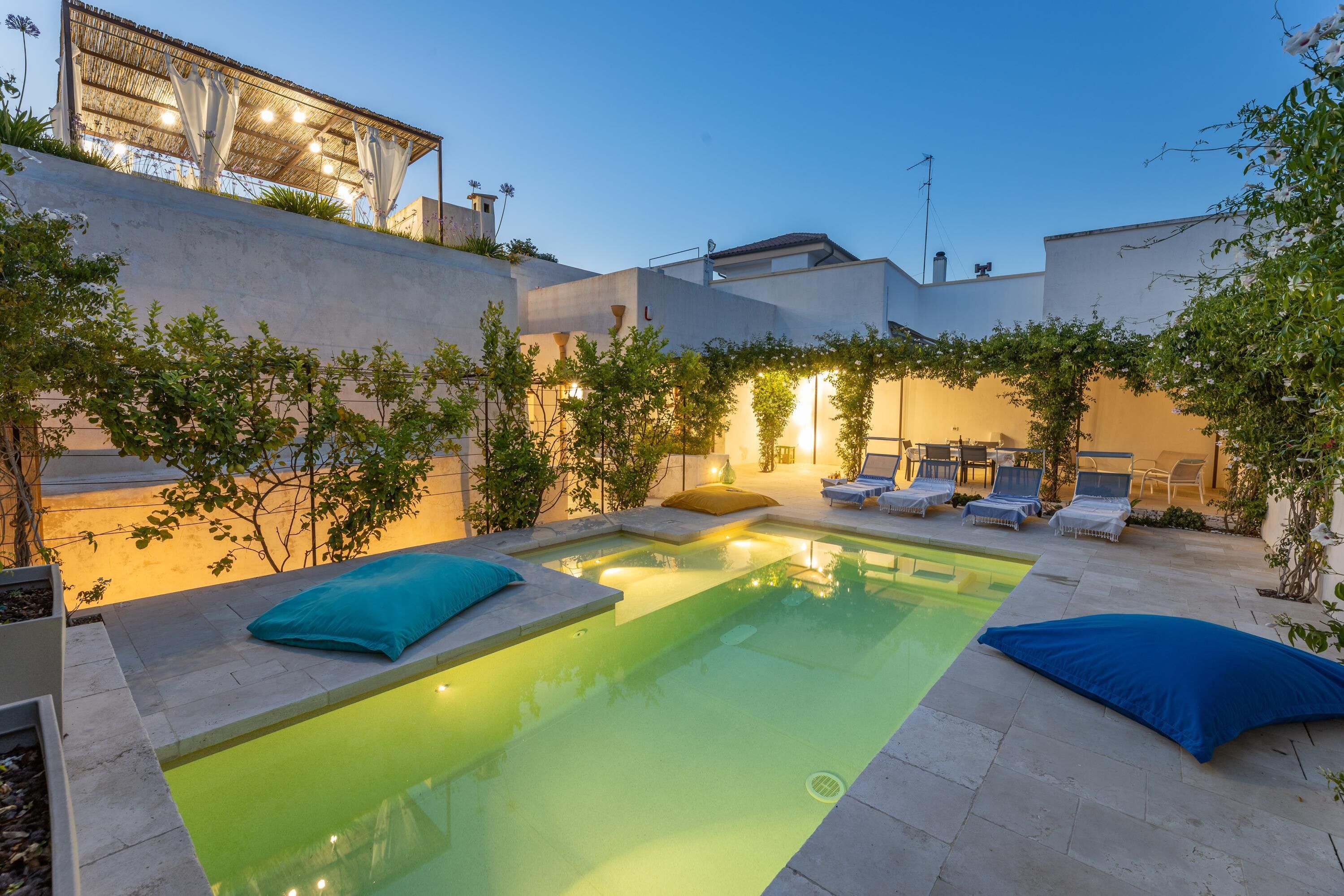 A rooftop pool area with lounge chairs and a small pool.