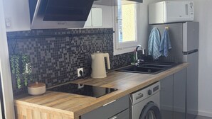 A compact kitchen with a dishwasher, washing machine, and a microwave. - Apartment with sunny terrace for 4 people 20 metres from the port  (Leucate)