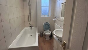 Ein Badezimmer mit Badewanne, Toilette und Waschbecken.