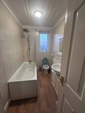 Een badkamer met een bad, toilet en wastafel.