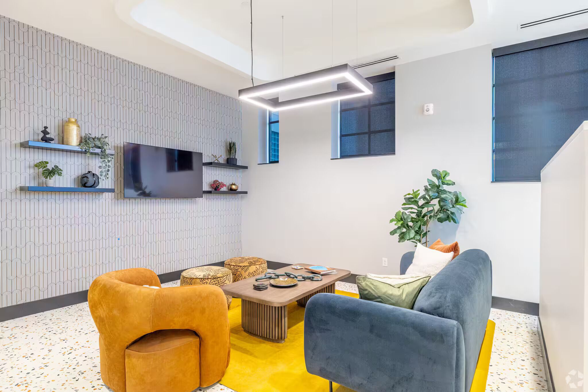 A modern living room with a flat-screen TV, a coffee table, and comfortable seating.