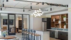 Une cuisine moderne dotée d’un îlot central, de tabourets de bar et d’un luminaire suspendu.