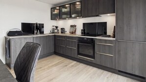 A modern kitchen with dark cabinetry, a built-in oven, and a coffee maker. - "Milan" - 20km from the sea by Interhome (Bredebro)