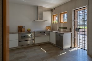 Una cocina moderna con electrodomésticos de acero inoxidable, horno empotrado y lavavajillas.