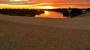 A wide sandy beach with a sunset in the background. - AREIAS HOTEL (Barreirinhas)