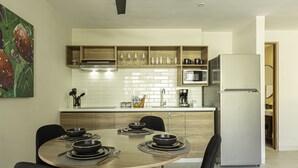 Une cuisine moderne équipée d’une table à manger pour quatre personnes, d’un four à micro-ondes et d’un réfrigérateur.