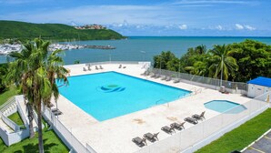 Una piscina con vistas al mar y un paisaje montañoso al fondo.