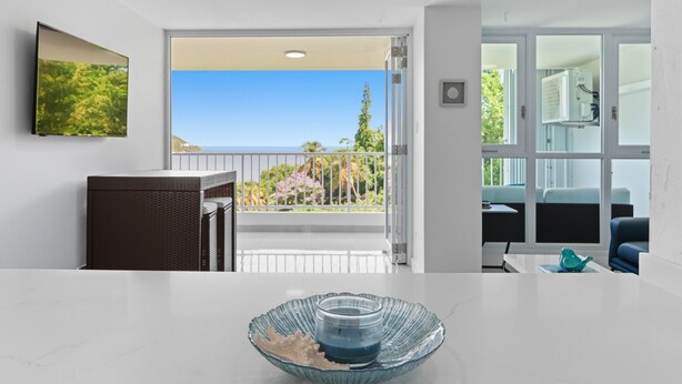 Una sala de estar moderna con balcón, comedor y vistas al exterior.