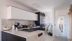 Una cocina moderna con encimera de mármol, electrodomésticos integrados y un diseño elegante.