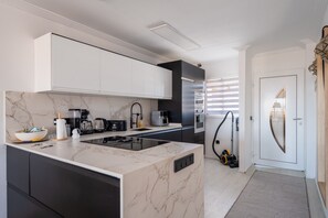 Eine moderne Küche mit Marmorarbeitsplatte, integrierten Geräten und einem eleganten Design.