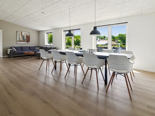 A modern kitchen with a dining area, large windows, and a living room with a sofa and coffee table. - "Biergh" - 30km from the sea by Interhome (Toftlund)