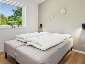 Un dormitorio con cama, ventana y decoración en la pared.