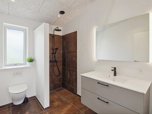 A modern bathroom with a shower, toilet, and vanity with a mirror. - "Biergh" - 30km from the sea by Interhome (Toftlund)