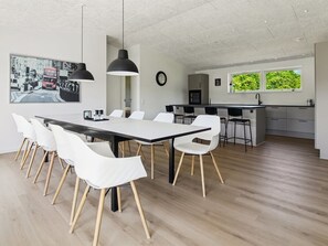 A modern kitchen with a large island, white chairs, and a dining table. - "Biergh" - 30km from the sea by Interhome (Toftlund)