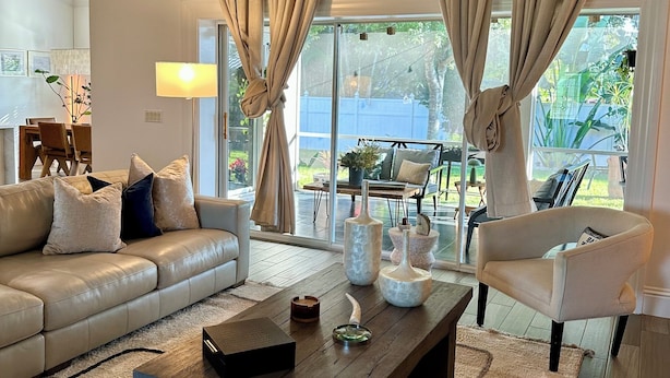 A modern living room with a leather sofa, a wooden coffee table, and a chair. - Bright 3BR Family Home • 15min to Beach • Quiet, Clean & Comfortable (Fort Myers)