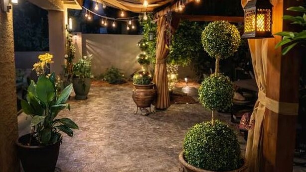 A courtyard with string lights, potted plants, and a lantern. - The Cozy Inn (Phoenix)