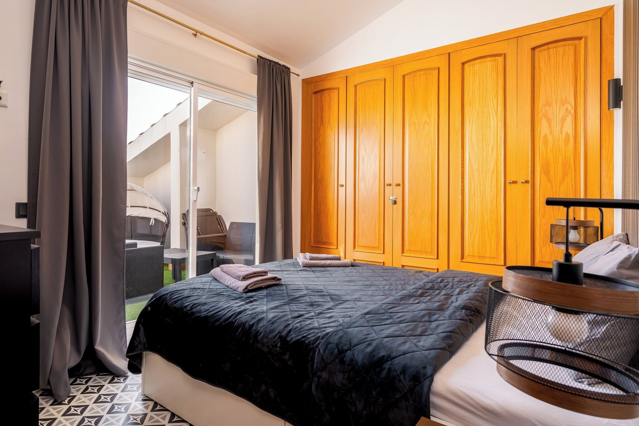 Ein Schlafzimmer mit Bett, Kleiderschrank, Schreibtisch und Stuhl.