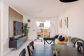 Apartamento superior, 3 habitaciones, vistas al mar, frente a la playa | Zona de estar | Smart TV de 75 pulgadas con canales por cable, libros