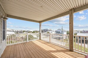 A covered porch with a wooden deck, white railings, and a view of neighboring houses. - Pet Friendly Spacious 3BR/3.5BA townhome — 2,034 sqft for families to spread out comfortably. Modern finishes, parking, water views. Walking distance to Atlantic Beach — ideal family beach retreat. Check/Zelle payment avail for direct bookings. (Atlantic Beach)